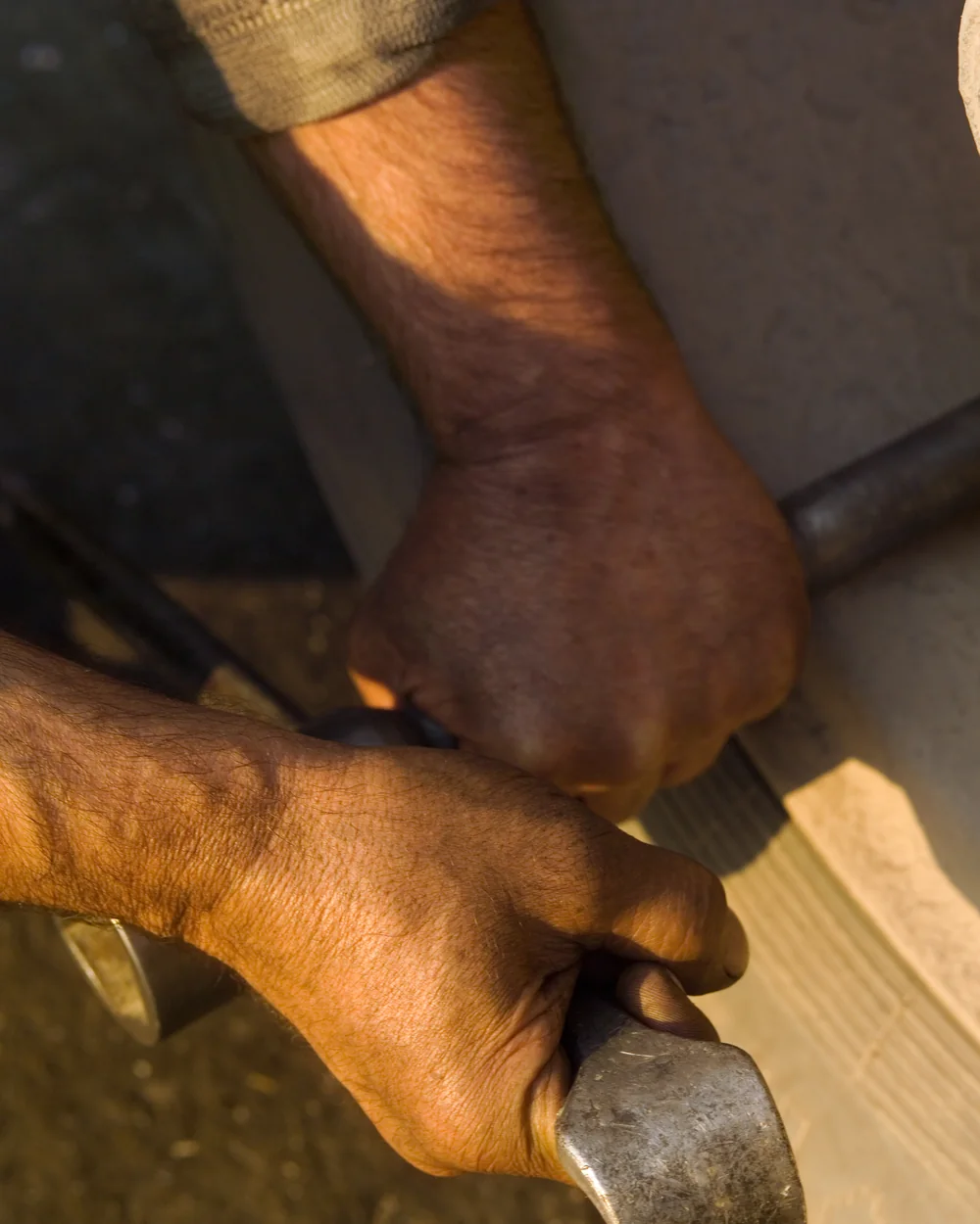 Mãos de prestador de serviço segurando ferramenta de trabalho
